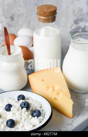 Les produits laitiers. Fromage, lait, yaourt, fromage blanc, la crème fraîche et les Œufs biologiques sur en arrière-plan. Vue rapprochée, selective focus Banque D'Images