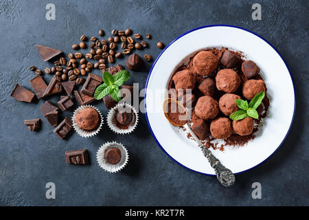 Truffes au chocolat noir fait maison, roulée dans de la poudre de cacao et les grains de café sur fond de béton bleu. Vue d'en haut Banque D'Images