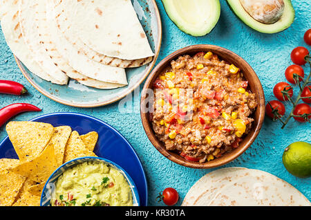 La nourriture mexicaine mix : nachos, fajitas, guacamole, tortillas et salsa sauces et ingrédients sur fond bleu. Vue d'en haut Banque D'Images