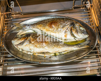 La cuisson du poisson au four à la maison cuisine Banque D'Images