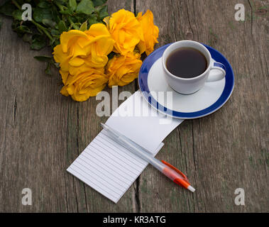 Des roses jaunes, le café et la poignée avec un ordinateur portable sur une table minable Banque D'Images