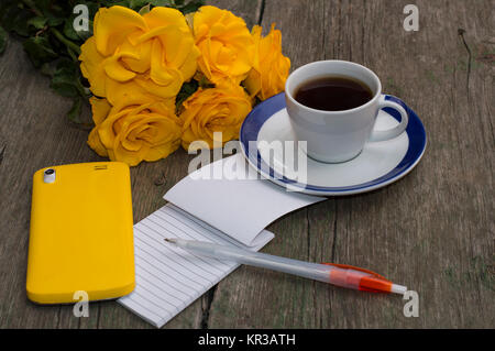 Des roses jaunes, ordinateur portable, café et téléphone jaune Banque D'Images