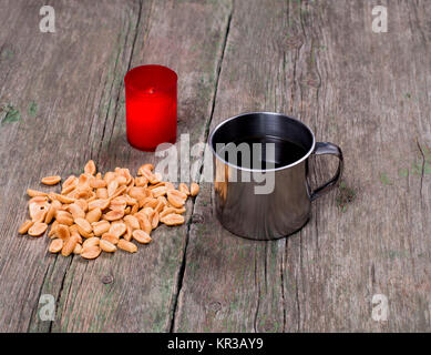 La bougie allumée, l'acier mug et d'arachide Banque D'Images