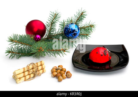 Plaque noire avec gâteau rouge, une branche de sapin, cookies et nucule Banque D'Images