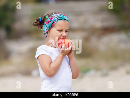 Baby Girl mange une peach Banque D'Images