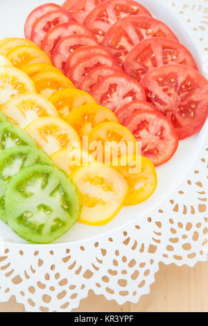 Tranches de produits frais bio, rouge, vert et tomates jaunes Banque D'Images