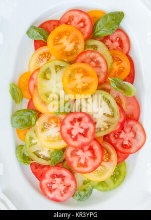 Tranches de produits frais bio, rouge, vert et tomates jaunes Banque D'Images