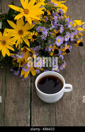 Bouquet de fleurs sauvages et tasse de café sur une table en bois, la vue de dessus Banque D'Images