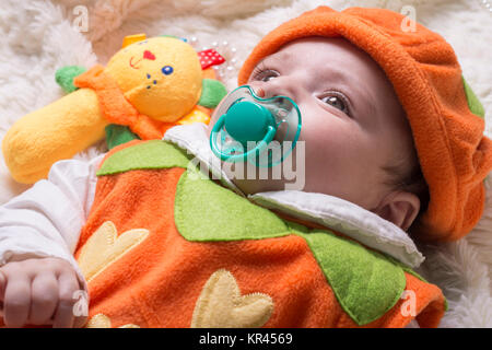 Close-up portrait of a little baby girl avec sucette allongé sur le furry couverture blanche, low angle view point. Banque D'Images