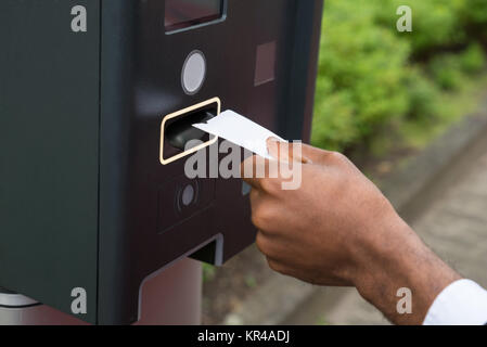 Close-up of Person's Hand insertion de billet dans un parcomètre Banque D'Images