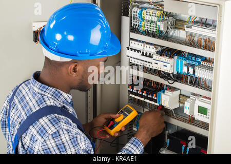 L'examen de technicien Fusebox avec sonde du multimètre Banque D'Images