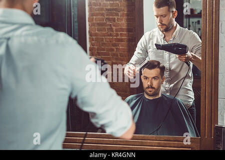 Jeune beau salon de coiffure de décisions de coupe homme séduisant dans ce type de Banque D'Images