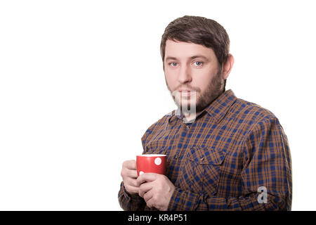 Homme barbu en chemise à carreaux avec tasse rouge dans ses mains. Isolé sur fond blanc Banque D'Images