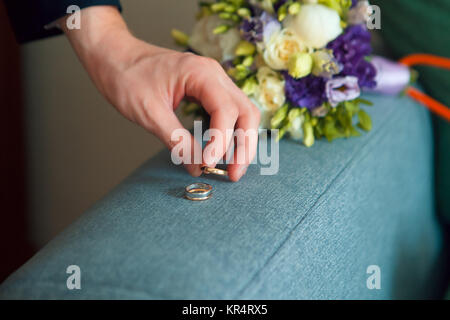 Groom prend l'anneaux d'or à partir de la table Banque D'Images
