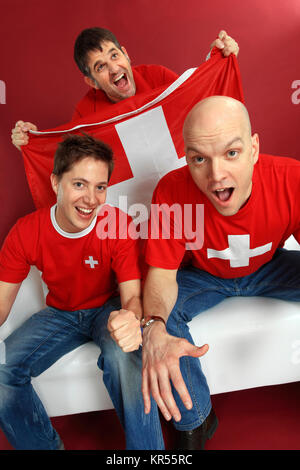 Photo de trois sports fans cheering Suisse mâle pour leur équipe. Banque D'Images