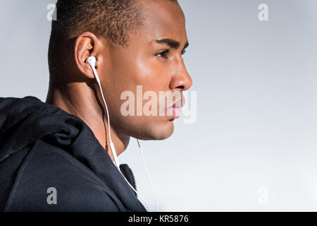 Portrait de profil de young african american man listening music des écouteurs Banque D'Images