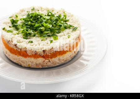 Salade en couches avec des œufs et du poisson sur le fond blanc Banque D'Images