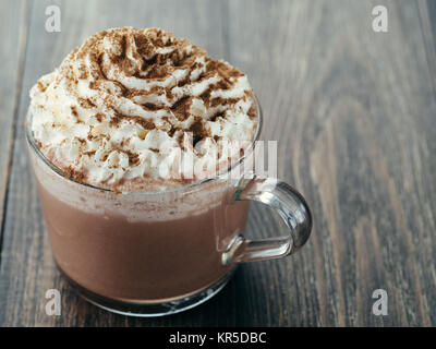Tasse en verre avec du chocolat chaud et crème fouettée Banque D'Images