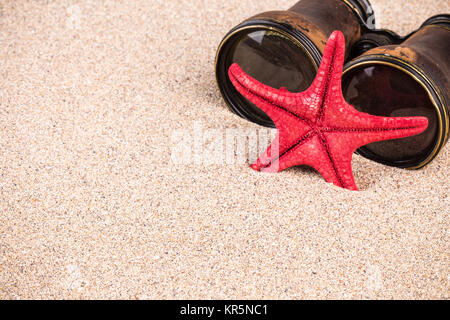 Les étoiles de mer et les jumelles sur le sable Banque D'Images