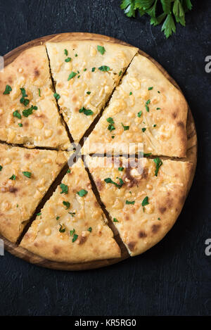 Pain plat traditionnel géorgien - khachapuri ou hachapuri avec double fromage. Imereti khachapuri sur noir table de pierre avec l'exemplaire de l'espace. Banque D'Images