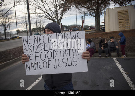 Marietta, GA, USA. Dec 18, 2017. Un père de trois enfants hispaniques, les chômeurs et les non-anglophones, plaide pour aider à nourrir sa famille, sitting on curb en stationnement d'un centre commercial. Seulement leur jeune fils est bilingue. Crédit : Robin Rayne Nelson/ZUMA/Alamy Fil Live News Banque D'Images