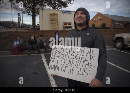 Marietta, GA, USA. Dec 18, 2017. Un père de trois enfants hispaniques, les chômeurs et les non-anglophones, plaide pour aider à nourrir sa famille, sitting on curb en stationnement d'un centre commercial. Seulement leur jeune fils est bilingue. Crédit : Robin Rayne Nelson/ZUMA/Alamy Fil Live News Banque D'Images