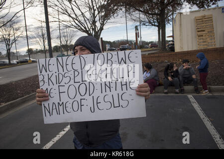 Marietta, GA, USA. Dec 18, 2017. Un père de trois enfants hispaniques, les chômeurs et les non-anglophones, plaide pour aider à nourrir sa famille, sitting on curb en stationnement d'un centre commercial. Seulement leur jeune fils est bilingue. Crédit : Robin Rayne Nelson/ZUMA/Alamy Fil Live News Banque D'Images