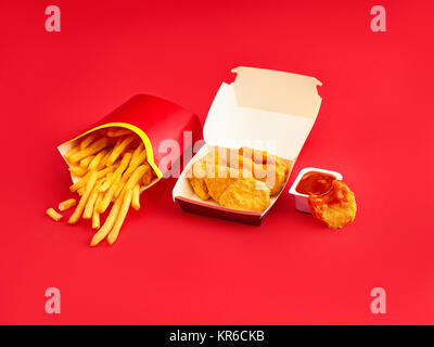 Nuggets de poulet et frites sur fond rouge Banque D'Images