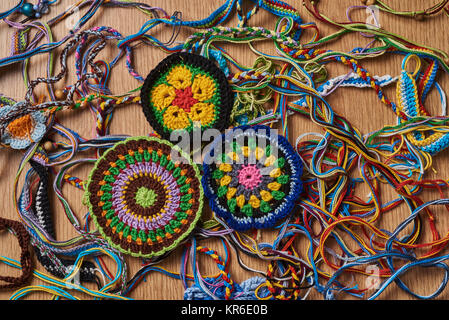 Différents types de bracelets colorés tricotés et boucles d'sont chaotiquement allongé sur la table. En bas à gauche il y a trois grosses étoffes amule Banque D'Images