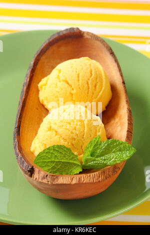 Glace jaune-crème dans un bol en bois Banque D'Images