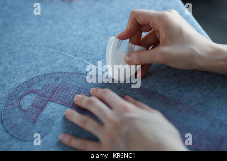 De Gros plan sur mesure et marquage des mains de mesure alors que la fabrication de vêtements en tissu. Banque D'Images