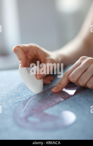 De Gros plan sur mesure et marquage des mains de mesure alors que la fabrication de vêtements en tissu. Banque D'Images