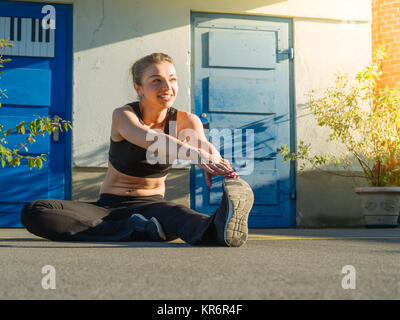 Young woman stretching outdoors Banque D'Images