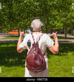 Gris Senior woman showing Thumbs up in the park Banque D'Images