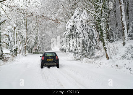 Dacia Duster en voiture sur une route de campagne enneigée près de Snowshill village en décembre. Snowshill, Cotswolds, Gloucestershire, Angleterre Banque D'Images