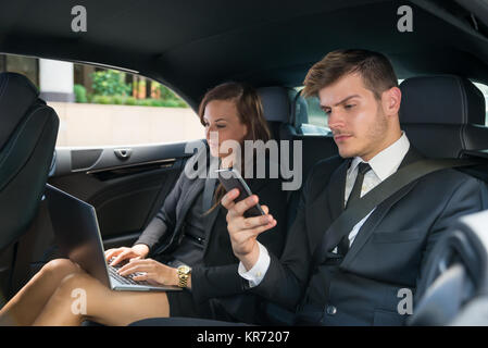 Young Businessman And Businesswoman dans la voiture Banque D'Images