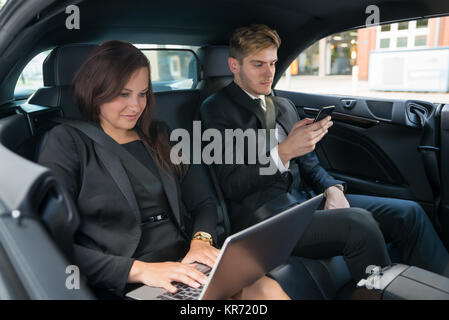 Young Businessman And Businesswoman dans la voiture Banque D'Images