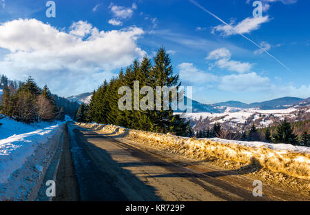 Route à travers des forêts en hiver. belle nature paysage avec arbres par jour nuageux. belle arrière-plan de transport. Banque D'Images