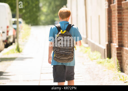 Schoolboy Walking on Sidewalk Banque D'Images