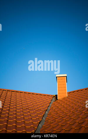 Red Roof avec tuiles d'argile et de la cheminée en face de ciel bleu sans nuages Banque D'Images