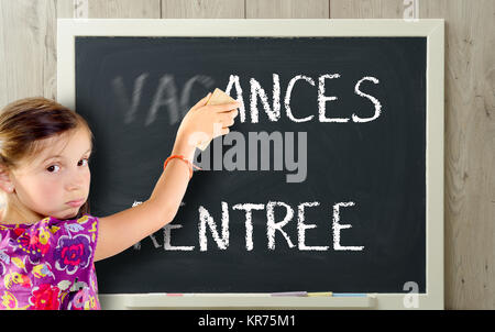 Une fille efface vacances sur tableau noir Banque D'Images