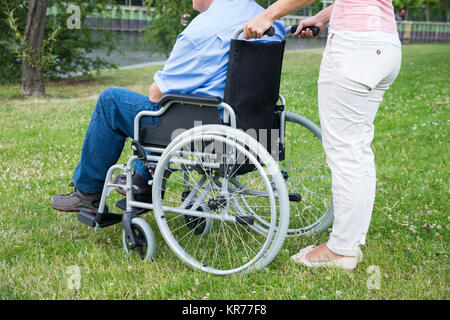 Femme Homme appuie les personnes sur fauteuil roulant Banque D'Images