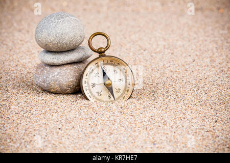 Vintage boussole avec pierres sur le sable Banque D'Images