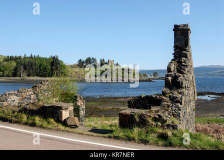 Un Crofters à ruiner sur la route côtière dans le Sound of Mull. De l'autre côté de la petite baie, les ruines de château Aros du 13e siècle. Il a été construit par le MacDo Banque D'Images