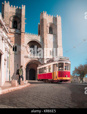 Circonscription de tramway passé Cathédrale Patriarcale de Sainte Marie Majeure sur une rue de galets, dans la vieille ville de Lisbonne, Portugal. Banque D'Images