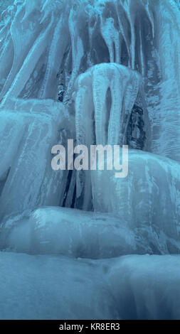 Cascade de glace d'eau. Mur de glace raide glissant vertical avec de longs glaçons. Banque D'Images