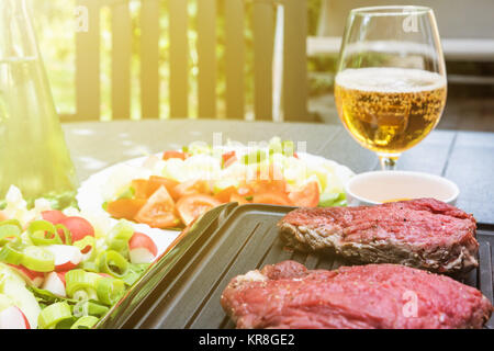 Steaks de cuisson sur la cuisinière électrique en soleil Banque D'Images