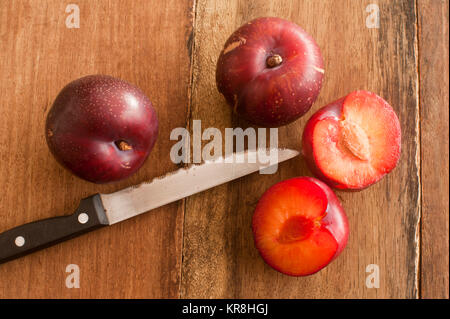 Les prunes organique et d'un couteau sur la table en bois Banque D'Images