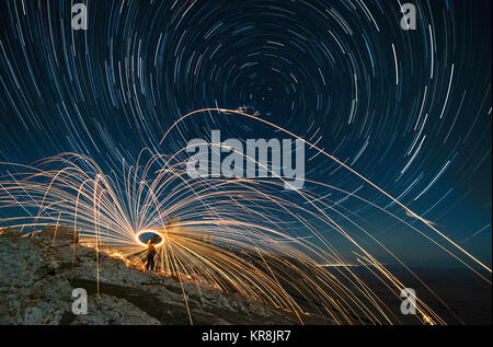 Une longue exposition image montrant star trails plus de forteresse médiévale Enisala et acier whool photographie, peinture de lumière dans la nuit. Banque D'Images