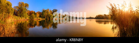 Coucher de soleil sur un lac, un panorama en or et bleu Banque D'Images